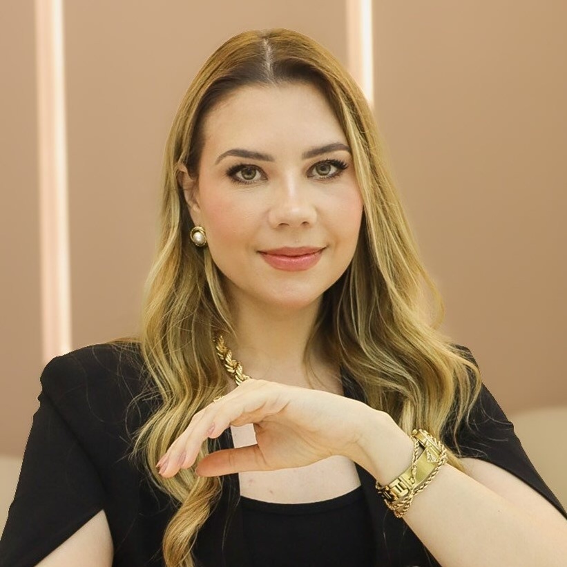 Dra Vanessa Mick, médica especialista em pneumologia pediátrica em Maringá, sorrindo em seu consultório